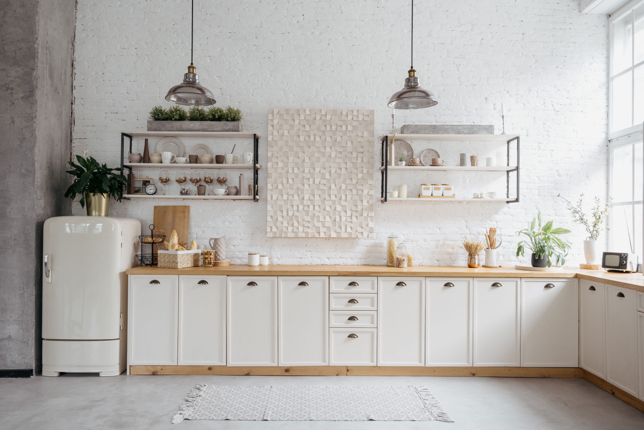 Η κουζίνα είναι σχεδιασμένη σε κλασικό στιλ με μοντέρνες πινελιές, αποπνέοντας ταυτόχρονα αίσθηση ζεστασιάς και κομψότητας. Τα κυρίαρχα χρώματα σε αυτό το χώρο είναι το λευκό και το κρεμ, δημιουργώντας έναν φωτεινό και αεράτο χώρο.